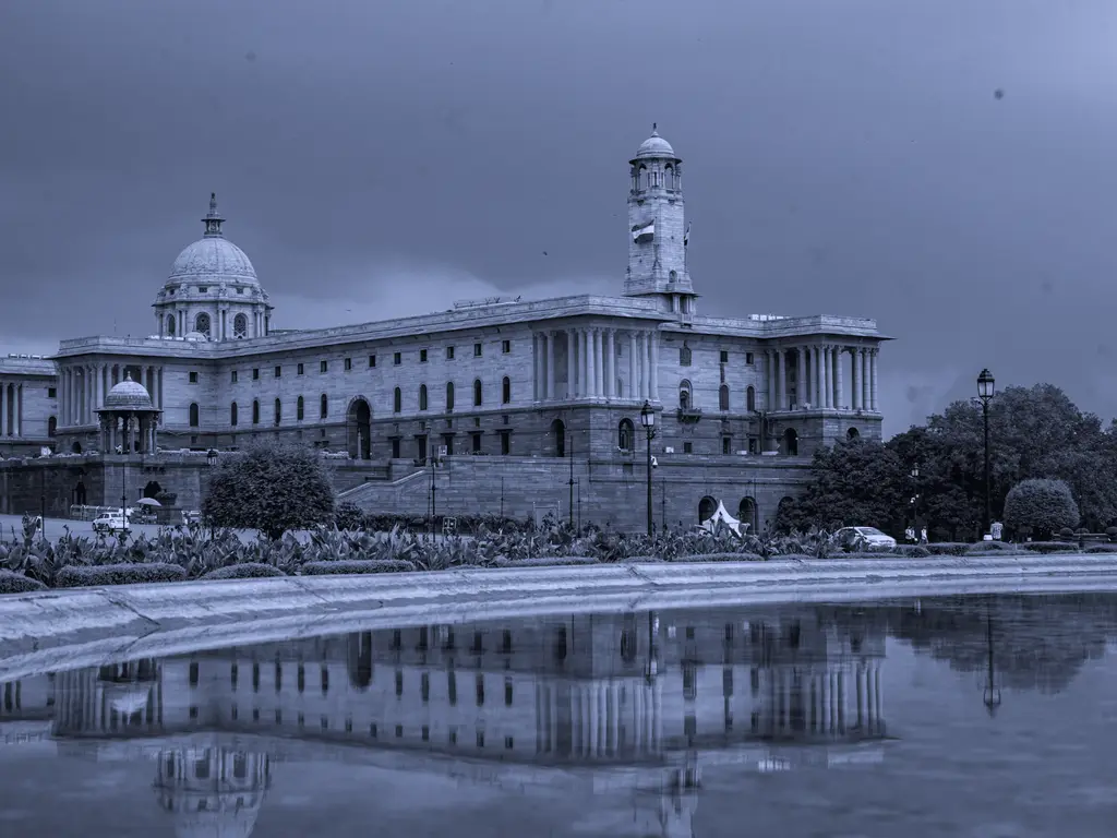 Colonnaded government building reflected in a pool
